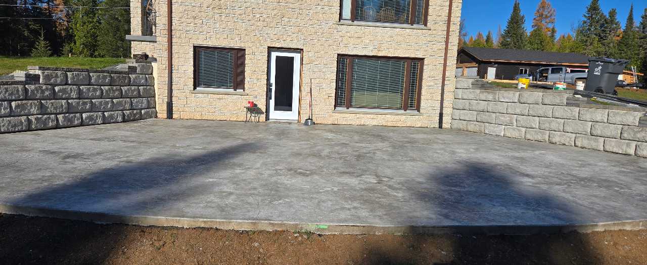 Concrete patio with retaining wall structure